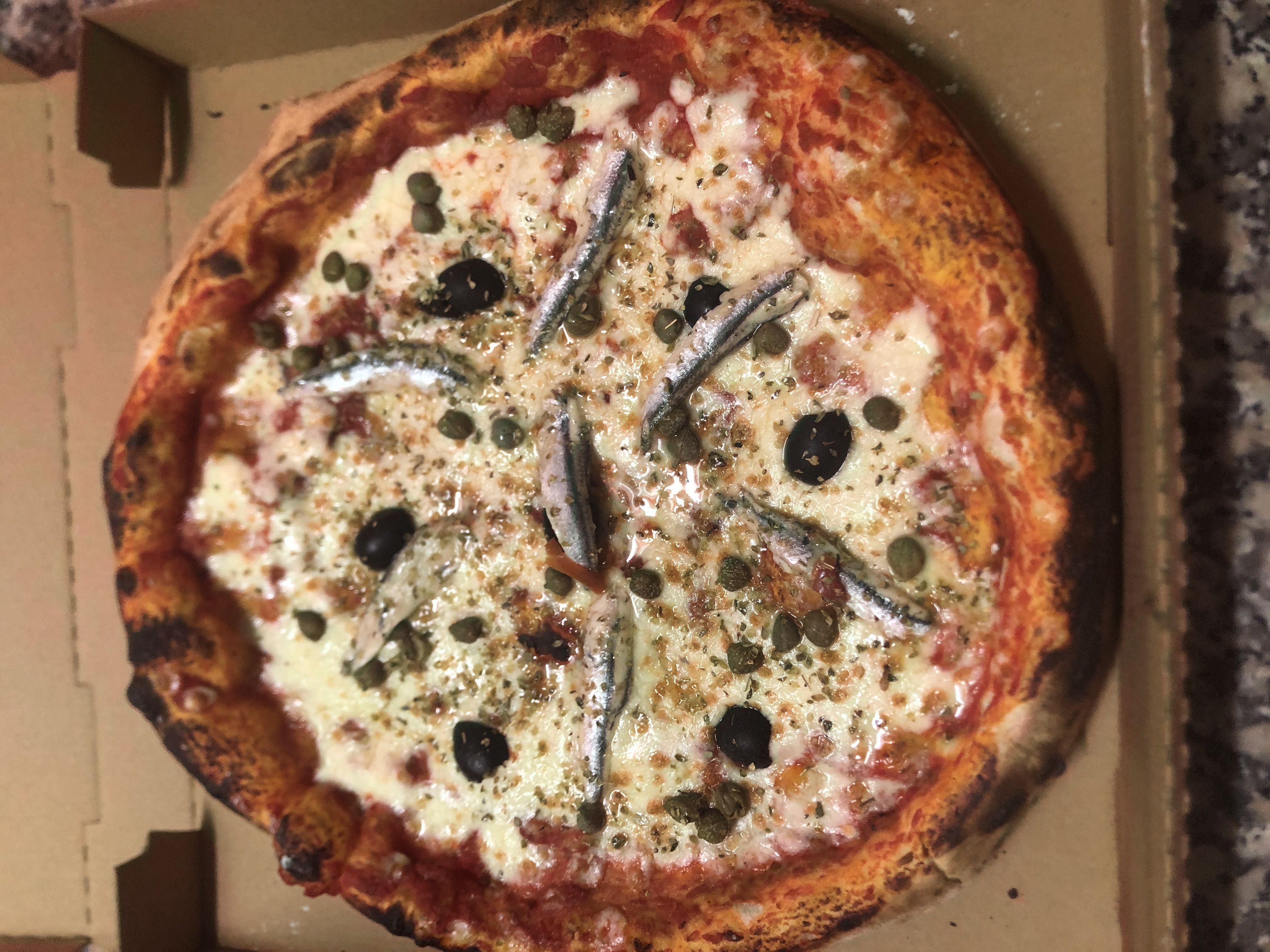 Pizza Napolitaine — anchois, câpres, olives noires, feu de bois